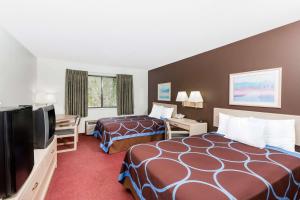 a hotel room with two beds and a flat screen tv at Super 8 by Wyndham Estherville in Estherville