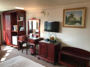 台南市にあるSunrise Hotelのデスクとテレビが備わるホテルルームです。
