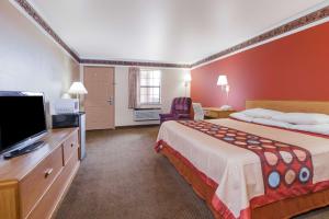 a hotel room with a bed and a flat screen tv at Super 8 by Wyndham Mount Vernon in Mount Vernon