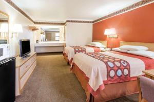 a hotel room with two beds and a flat screen tv at Super 8 by Wyndham Mount Vernon in Mount Vernon
