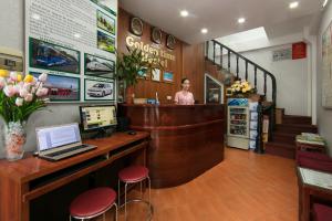 a woman standing at the cash register of a store at golden time hostel in Hanoi