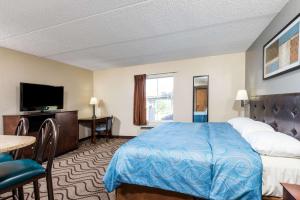 a hotel room with a bed and a flat screen tv at Super 8 by Wyndham Mars/Cranberry/Pittsburgh Area in Cranberry Township