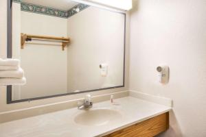 a bathroom with a sink and a large mirror at Super 8 by Wyndham Richfield Cleveland in Richfield