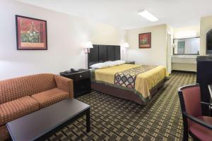 a hotel room with a bed and a couch at Super 8 by Wyndham Decatur/Lithonia/Atl Area in Decatur