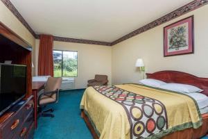 a hotel room with a bed and a flat screen tv at Super 8 by Wyndham Piedmont Greenville Area in Piedmont