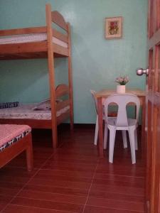 1 dormitorio con mesa y litera en 3Kid's Homestay Green, en General Luna