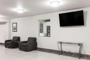 a waiting room with two chairs and a flat screen tv at Super 8 by Wyndham Grande Prairie in Grande Prairie