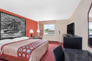 a hotel room with a bed and a television at Super 8 by Wyndham Bulls Gap Greeneville Area in Bulls Gap
