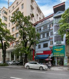 a white car parked in front of a building at golden time hostel in Hanoi