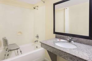a bathroom with a sink and a mirror and a bath tub at Super 8 by Wyndham Lithonia in Decatur +21 photos