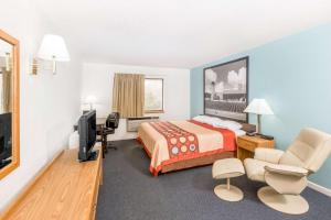 West Point Inn & Suites في West Point: غرفة فندقية بسرير وتلفزيون بشاشة مسطحة