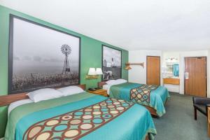 a hotel room with two beds and a picture of a windmill at West Point Inn & Suites in West Point