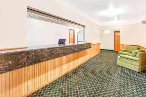 a waiting room with a chair and a mirror at Super 8 by Wyndham McHenry Fox Lake Area in McHenry