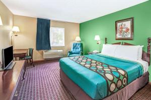 a hotel room with a large bed and a television at Super 8 by Wyndham McHenry Fox Lake Area in McHenry