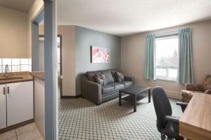 un salon avec un canapé et une table dans l'établissement Travelodge by Wyndham Edmonton Airport, à Leduc