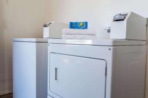 a white washing machine with towels on top of it at Travelodge by Wyndham Merced Yosemite in Merced