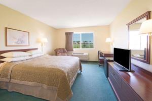 a hotel room with a bed and a flat screen tv at Super 8 by Wyndham Richmond in Richmond