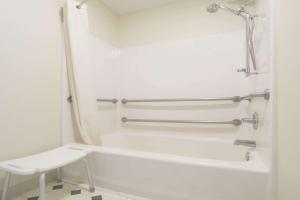 uma casa de banho branca com uma banheira e um WC em Super 8 by Wyndham Richmond em Richmond