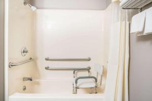 
a white bath tub sitting next to a white toilet at Days Inn & Suites by Wyndham Wausau in Wausau
