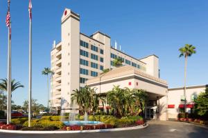 un hôtel avec une fontaine en face d'un bâtiment dans l'établissement Ramada by Wyndham Kissimmee Gateway - Free Theme Park Shuttle, à Orlando