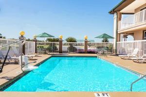 a swimming pool at a resort with chairs at Super 8 by Wyndham Marianna in Marianna