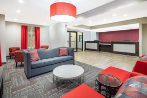a living room with a couch and a piano at Ramada by Wyndham Alpharetta Atlanta North in Alpharetta
