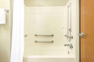 a bathroom with a shower and a bath tub at Super 8 by Wyndham Pevely in Pevely +12 photos
