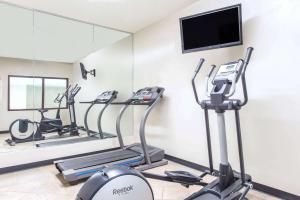 a gym with cardio machines and a flat screen tv at Super 8 by Wyndham Pevely in Pevely