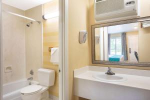 a bathroom with a toilet and a sink and a mirror at Howard Johnson by Wyndham Rocky Hill in Rocky Hill