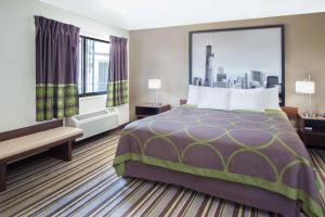 a hotel room with a bed and a large window at Super 8 by Wyndham Chicago/Rosemont/O'Hare/SE in River Grove