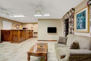 uma sala de estar com um sofá e uma mesa em Super 8 by Wyndham Booneville em Booneville