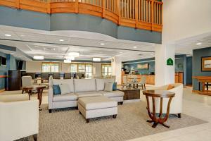 a lobby with a couch and chairs and a table at Wingate by Wyndham Fargo in Fargo