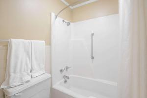 a bathroom with a white tub and a shower with towels at Super 8 by Wyndham Jasper in Jasper +19 photos