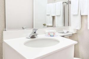 Un baño con un lavabo blanco y un espejo. en Travelodge by Wyndham La Grande, en La Grande