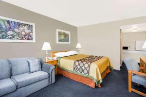 ein Hotelzimmer mit einem Bett, einem Sofa und einem Stuhl in der Unterkunft Super 8 by Wyndham Quesnel BC in Quesnel