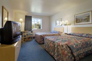 a hotel room with two beds and a television at Super 8 by Wyndham Ava in Ava