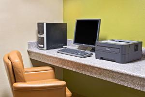 a desk with a computer and a printer on it at Super 8 by Wyndham Intercontinental Houston TX in Humble