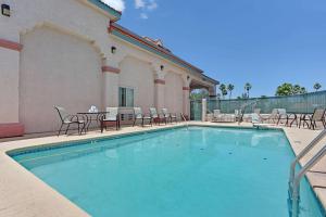 a large swimming pool with chairs and a table at Super 8 by Wyndham Tucson Downtown Convention Center in Tucson
