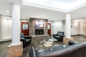 a lobby with a couch and chairs and a fireplace at Super 8 by Wyndham Red Deer City Centre in Red Deer