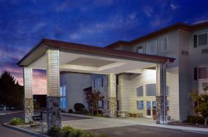 a large house with a lit up garage at Super 8 by Wyndham Central Pt Medford in Central Point