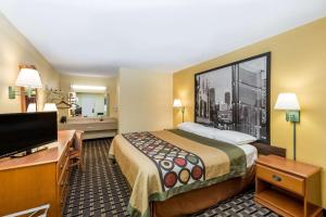 a large hotel room with a bed and a bathroom at Super 8 by Wyndham Indianapolis-Southport Rd in Indianapolis