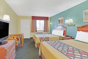 a hotel room with two beds and a flat screen tv at Super 8 by Wyndham Tucson Downtown Convention Center in Tucson