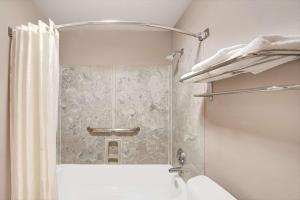 a bathroom with a shower with a toilet and a sink at Super 8 by Wyndham Richardson Dallas in Richardson