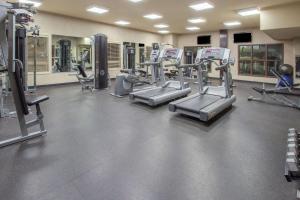 a gym with several treadmills and elliptical machines at Ramada by Wyndham Camrose in Camrose