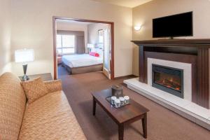 a living room with a couch and a fireplace at Ramada by Wyndham Drumheller Hotel & Suites in Drumheller