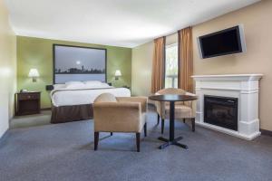 a hotel room with a bed and a fireplace at Super 8 by Wyndham Midland in Midland