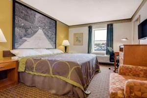 um quarto de hotel com uma cama, uma secretária e uma janela em Super 8 by Wyndham Allentown em Allentown