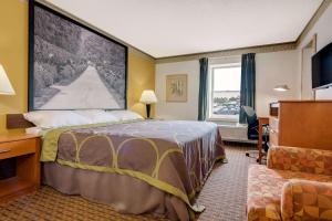 a hotel room with a bed and a desk and window at Super 8 by Wyndham Allentown in Allentown