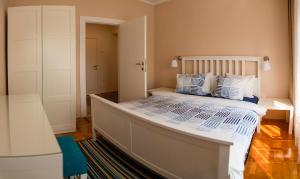 een slaapkamer met een groot bed met blauwe en witte kussens bij Apartman No.5 in Novi Sad