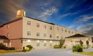オデッサにあるSuper 8 by Wyndham Odessa TXの頂上に時計塔がある大きな建物